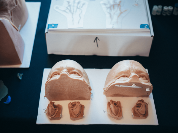 A photo of silicone prosthetics of an aged Bad Bunny sitting on the table.